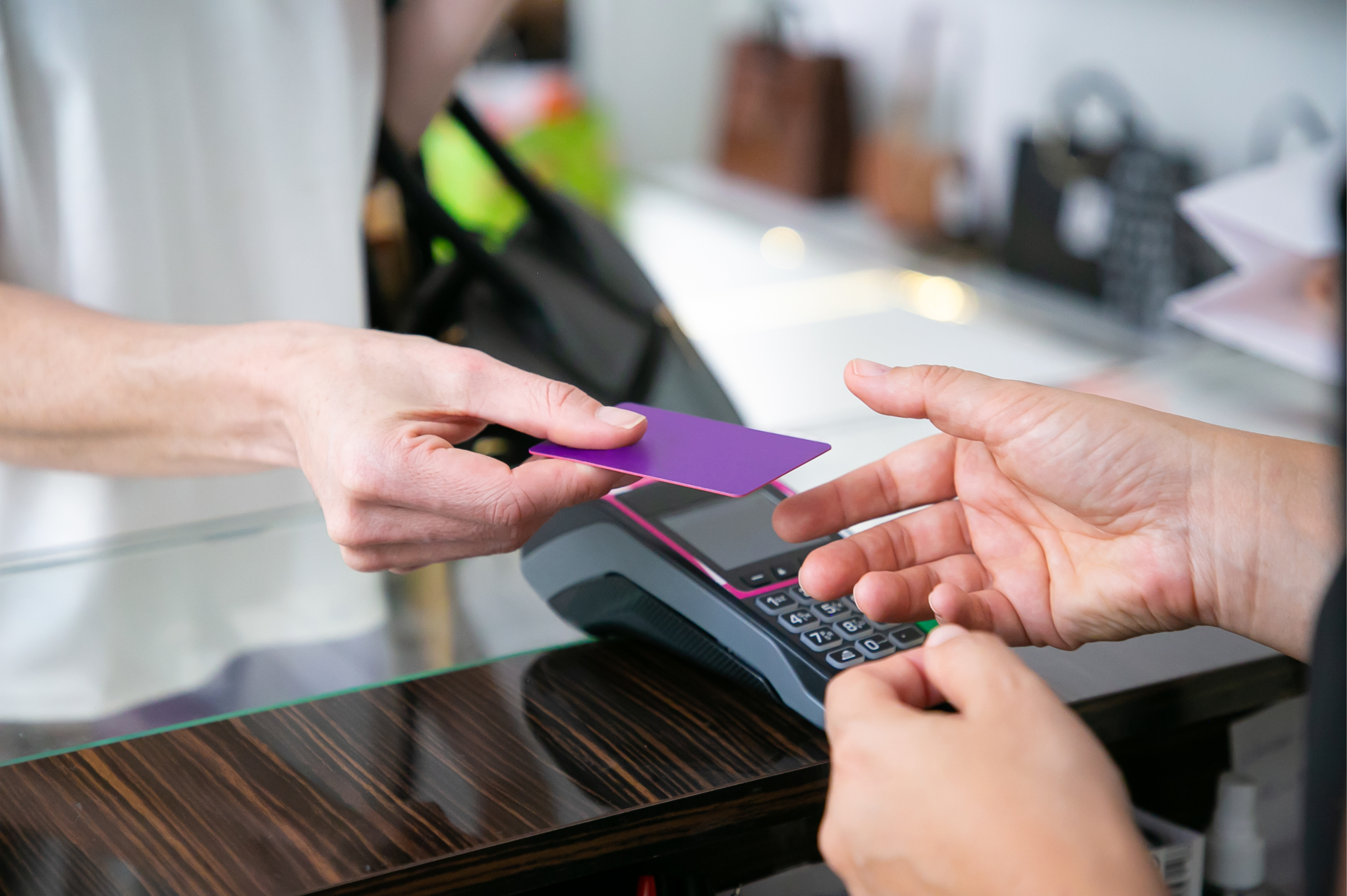 Guest tapping an RFID wristband at a cashless payment kiosk in a Family Entertainment Center